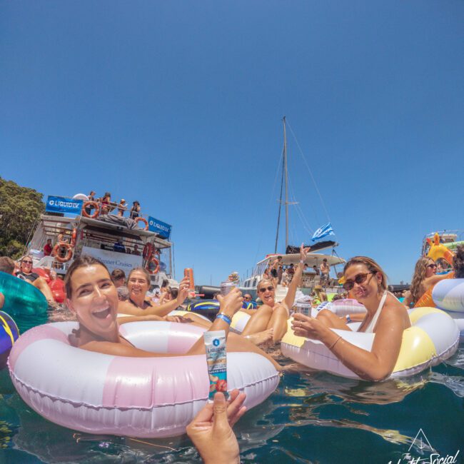 A group of people in inner tubes in water.